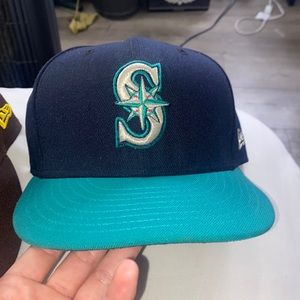 A seattle mariners hat and a san diego Padres hat
